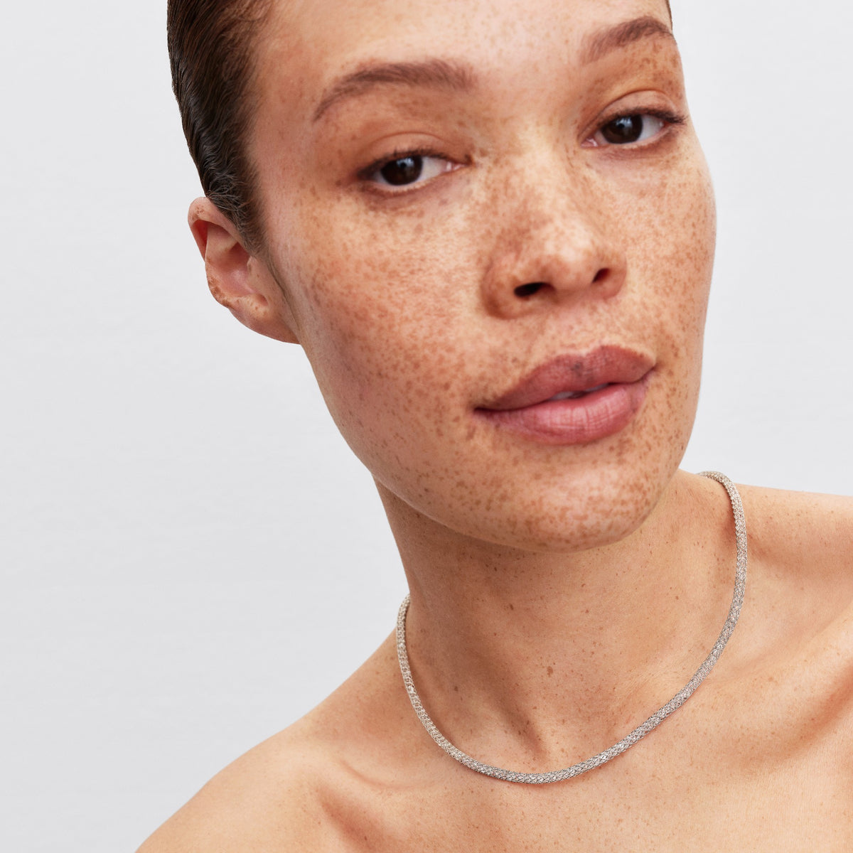 Model draagt de Pandora Hartsluiting Sprankelende Mesh Ketting platinaverguld